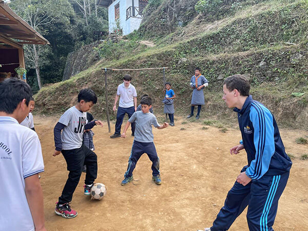 Playing football with young students at Phulingsum Primary School, near Punakha, Bhutan.