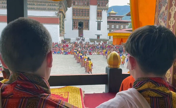 Owen and Archie observing Thimphu Dromchoe at Tashichoe Dzong in their traditional Gho robes.