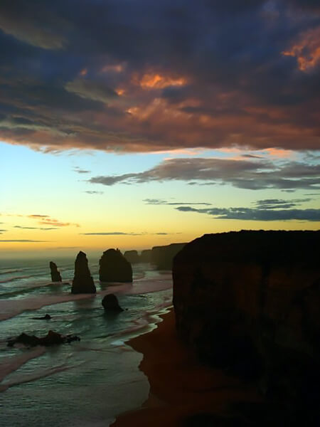 The spectacular Twelve Apostles jutting rocks along the shore at sunset.
