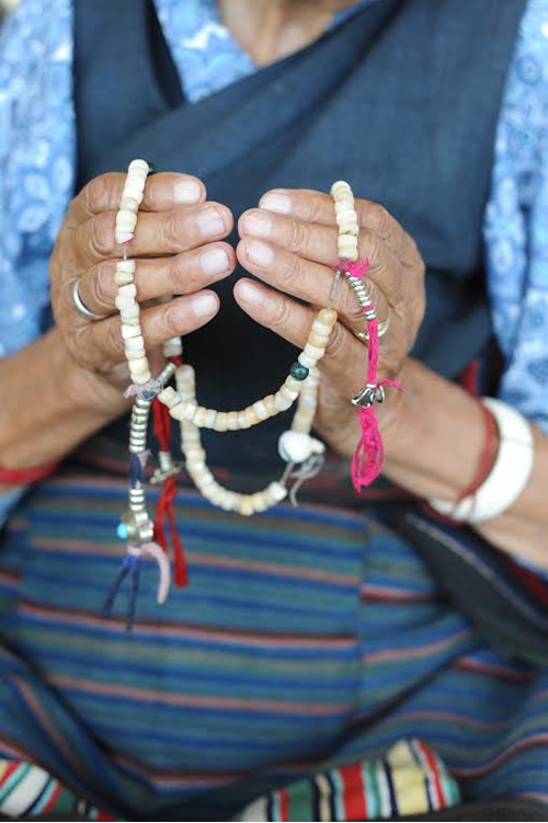 Host grandma with prayer beads in Dharamsala