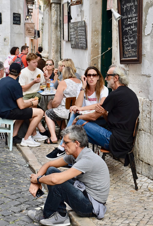 Eating and drinking on the narrow Alfama sidewalks, a historic district of Lisbon.