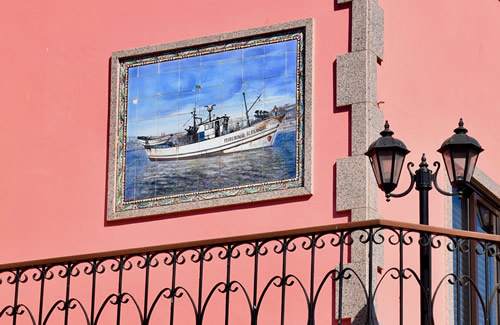Boats are depicted on the walls of houses in fishing village Afurada, Portugal.