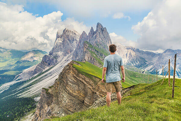 SSolo man in the Dolomites in Italy enjoying the view of the spectacular pointed mountain peaks.