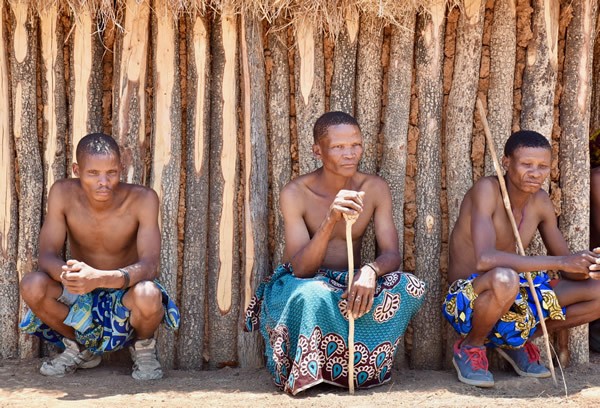Mugambue men in front of their hut in Angola.
