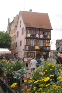 Colmar, Alsace, house with flowers along river.