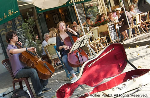 Street musicians in Paris playing in front of a cafe.