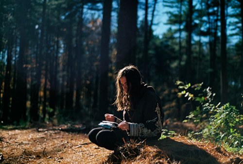 Teen reading in the woods
