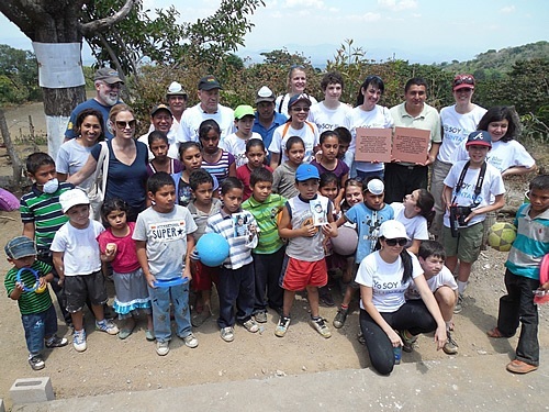 Glasswing volunteer team of teens with a community in El Salvador at the dedication of a school renovation.