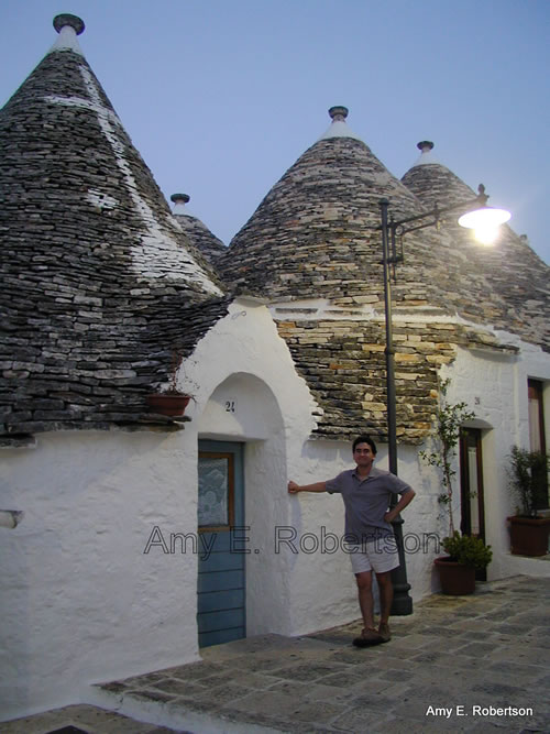 In front of trullo of Alberobello, Italy, where you can stay at an Albergo Diffuso.