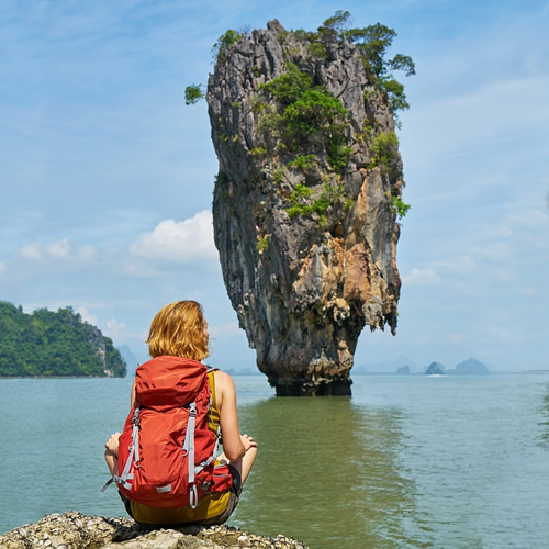 Admiring a rock formation in a Vietnam bay as the author is dressed in light clothes.