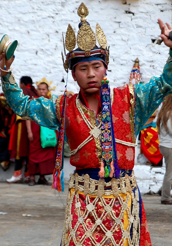 Bhutan Paro Festival where a man in costume dances with hand bells.