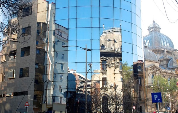 A modern glass building is one of many architectural styles in Bucharest.