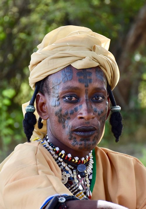 A Wodaabe man in Chad with face paint and colorful necklaces dressed for the festival.