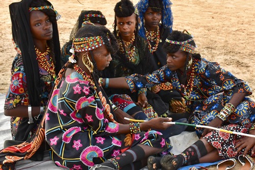 Young marriageable Wodaabe girls biding their time in anticipation of the Gerewol Festival performances.