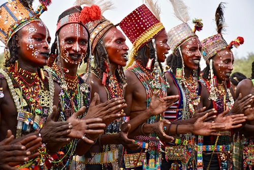 Young Wodaabe men in very colorful dress chanting and dancing.
