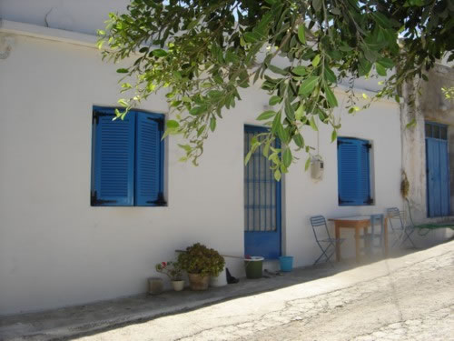 An old white house with blude shutters in Mochlos, Crete.