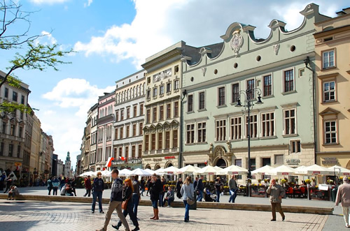 Main square busy with pedestrians in historic center of Krakow.