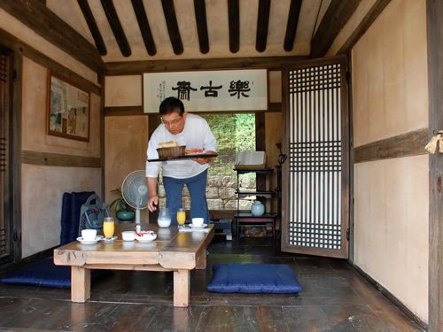 Observe local customs by eating breakfast on a porch hanok