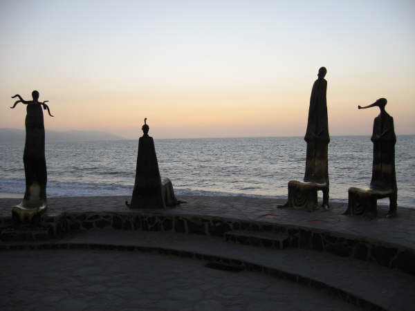 The beach town center with modern statues at sunset in Puerto Vallarta, Mexico.