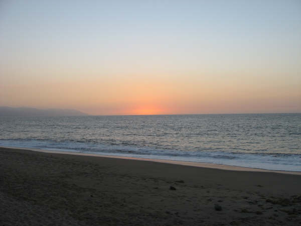 Beautiful sun is just setting into the ocean at a beach in Puerto Vallarta, Mexico.