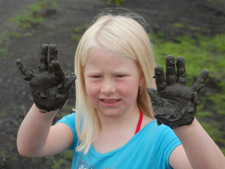 A child showing mud from the flooded grasslands.