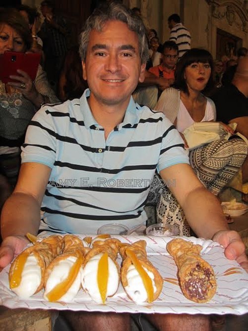 Luca offers cannoli in Sicily.