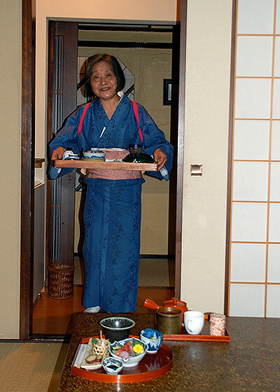 Dinner served at a ryokan by a hostess.
