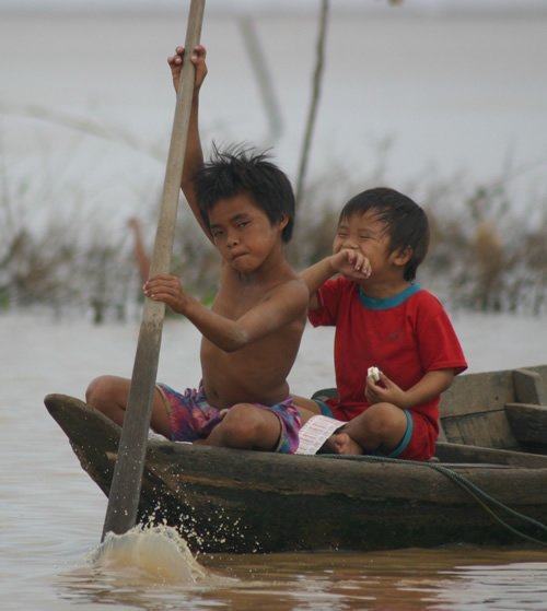Young children paddling in the Mekong River.