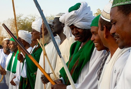 Sufi men gathered with sticks.