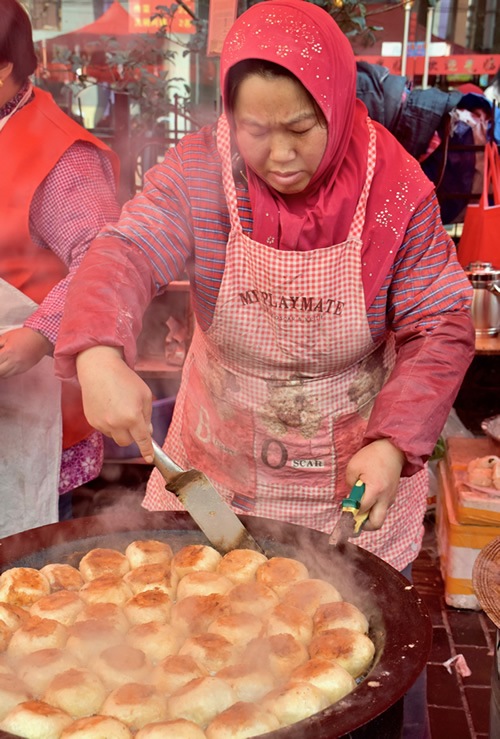Woman busy cooking at the Friday Muslim Market.