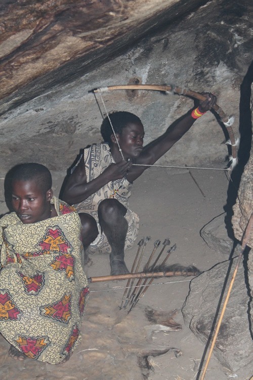 A Hadzabe woman checking out the bow and arrow pull.