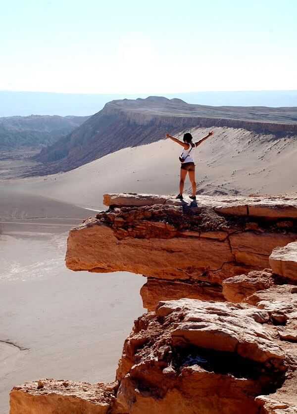 A woman raising her arms in astonishment at the Atacama desert in Northern Chile.
