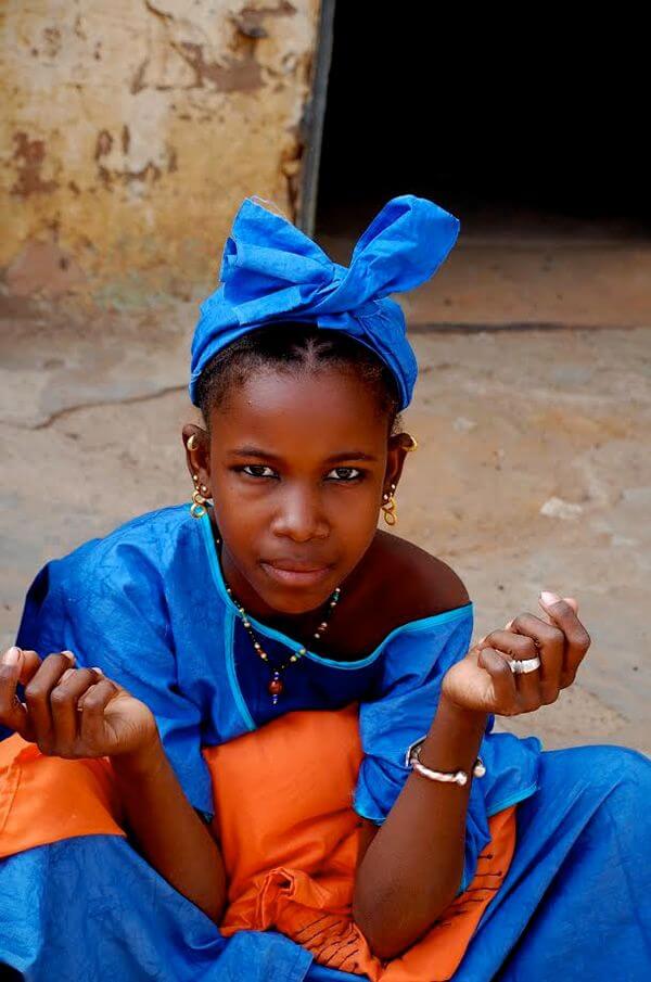 A teen girl in colorful dress at a market in Mali.