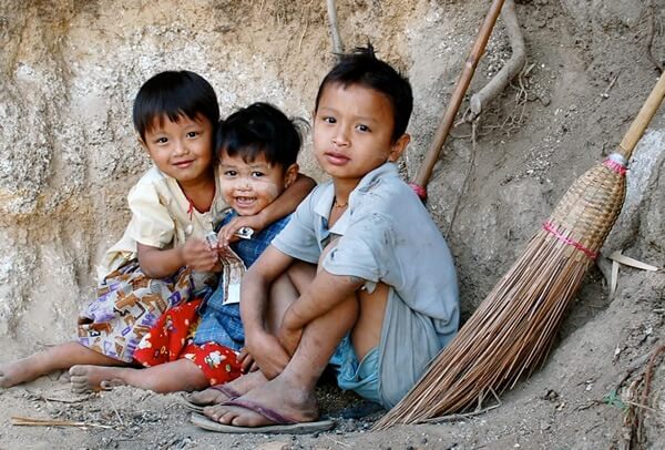 Three little children in a village in Myanmar.