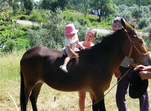 Family travel and education in Portugal. Child horseback riding.