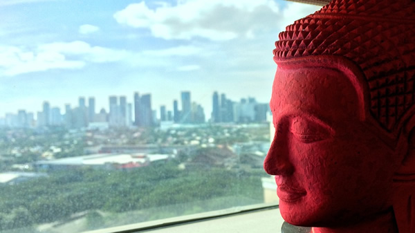 Apartment rental in Bangkok with a Buddha statue head overlooking the city skyline.
