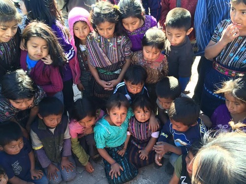 Young Mayan children gathered in Guatemala are playing a game.