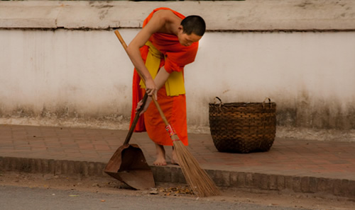 Monk sweeping the street.