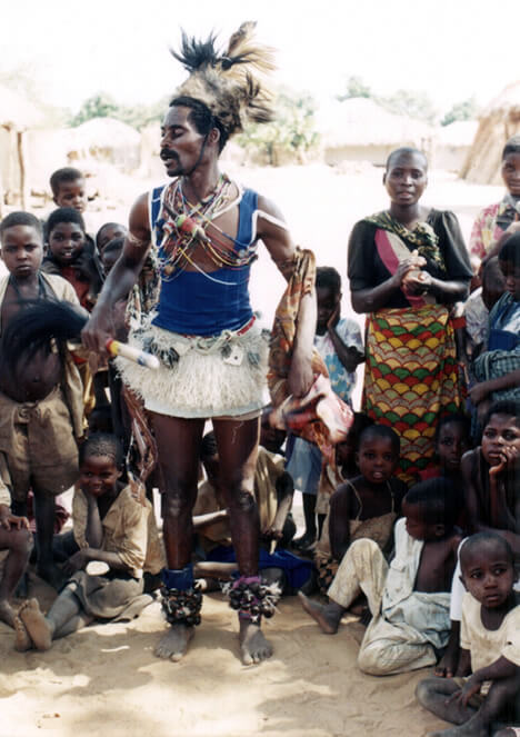 A man, a n'ganga, about to initiate an exorcism in Zambia traditionally dressed in a feather hat and a skirt.