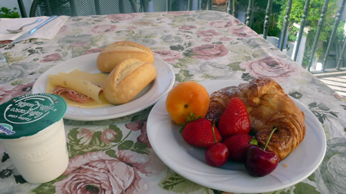 A fresh breakfast of fruits, croissant, bread, and yogurt at Palazzo Flora B & B in Puglia.