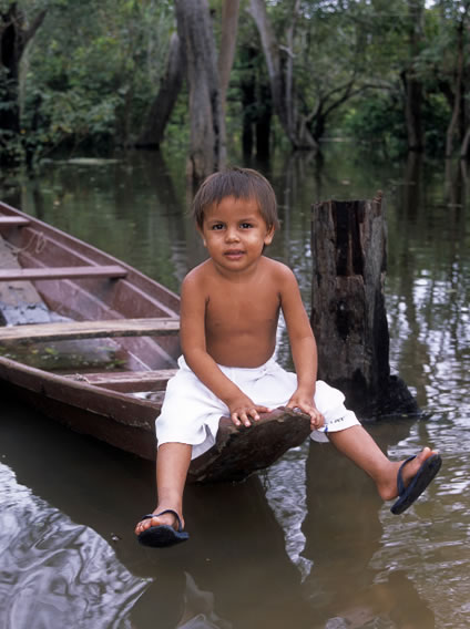 Boy sitting at the tip of a boat in Guatemala makes for a stunning photo subject.