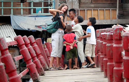 Woman showing kids her camera in Jakarta  —  Elaine.