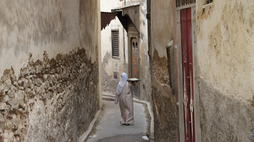 Woman takes bread to public oven in the medina of Fez.