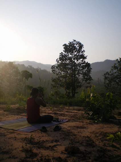 Woman teaching and learning yoga in nature abroad.