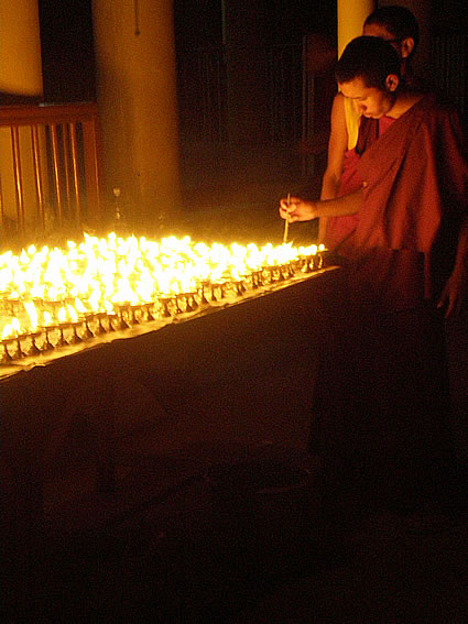 Lighting butter lamps at the Dalai Lama's temple.