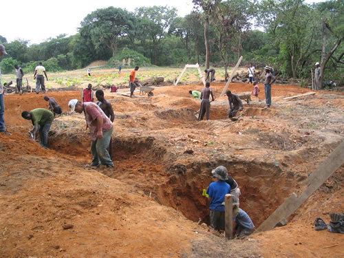 Volunteers and locals digging water reservoirs in Zambia.