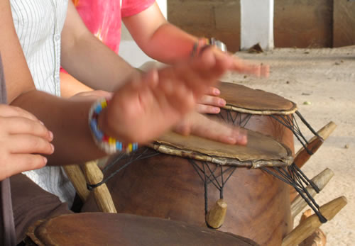 Drum Lessons in Accra, Ghana with hands tapping three drums.