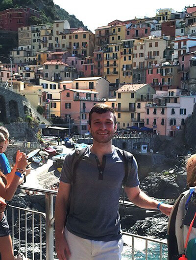Author on a bridge smiling in Cinque Terre, Italy.