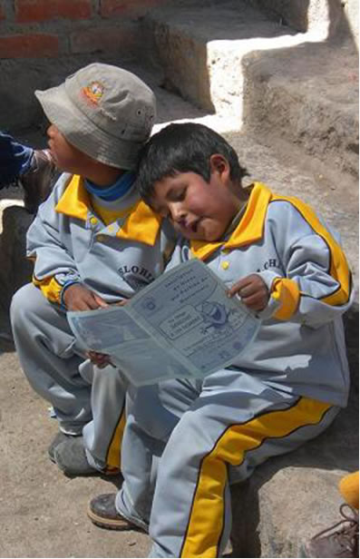 Children reading while sitting on a rock step in Chile.
