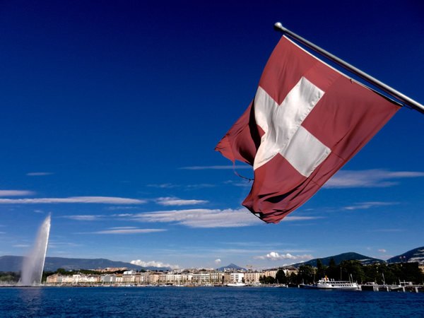 Geneva, Switzerland, seen from the lake with a flag waving in the wind while aboard a boat.